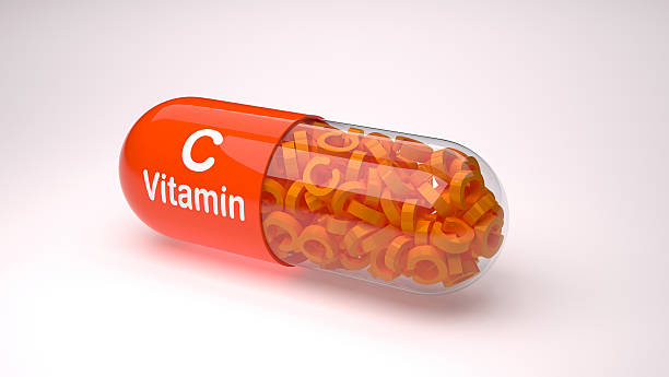 Orange pill or capsule filled with vitamin C. Vitamin capsules. vitamin c stock pictures, royalty-free photos & images