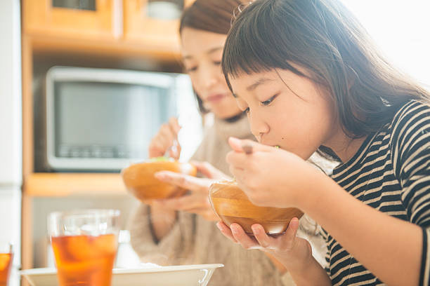 休日に一緒に昼食を食べる母と娘 - 日本人　親子 ストックフォトと画像