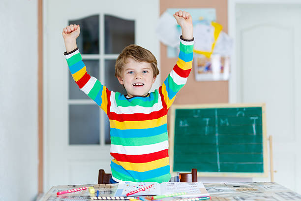 istock Happy school kid boy at home making homework 626781076