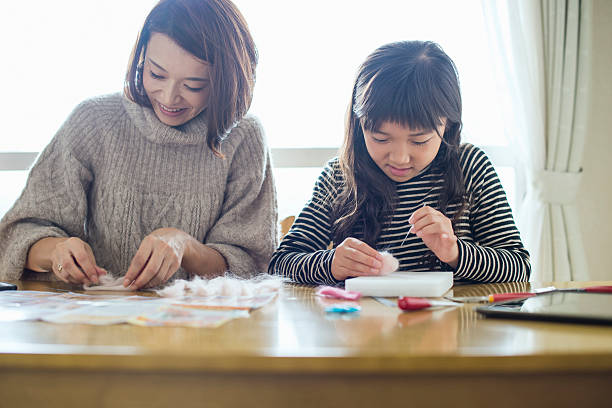 istock Daughter playing with mother with wool felt in room 626781882