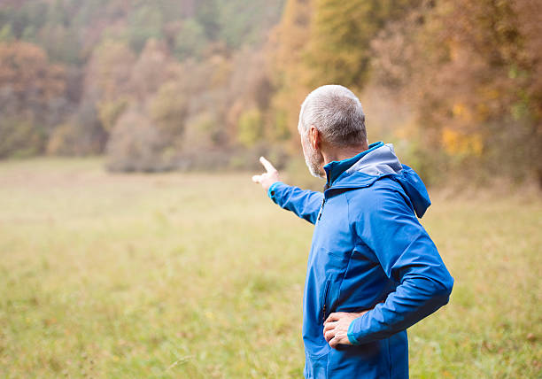 istock Senior runner resting outside in sunny autumn nature. 626785744
