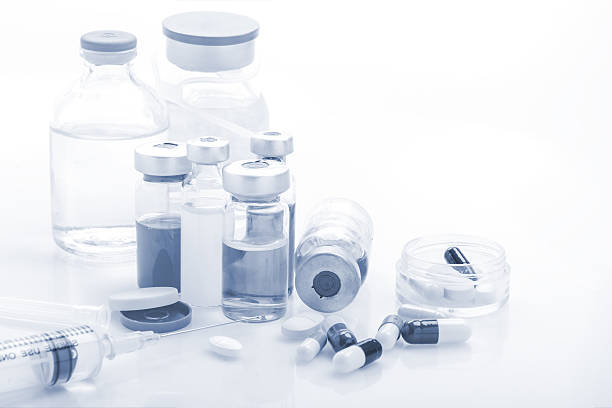 istock Glass Medicine Vials with syringe and pills capsule on white 626786566