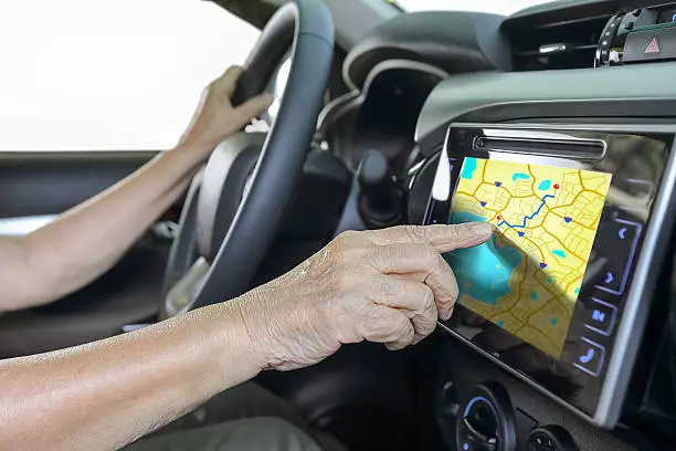 Photo of Elderly woman using GPS navigation system in car