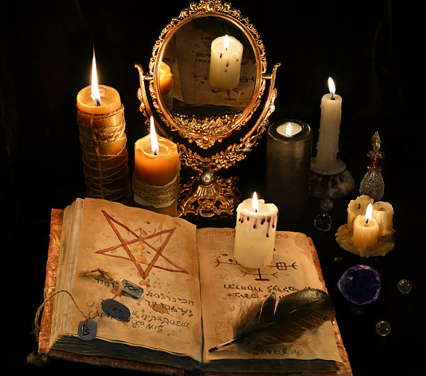 istock Mystic still life with black magic book, candles and mirrow 626787492