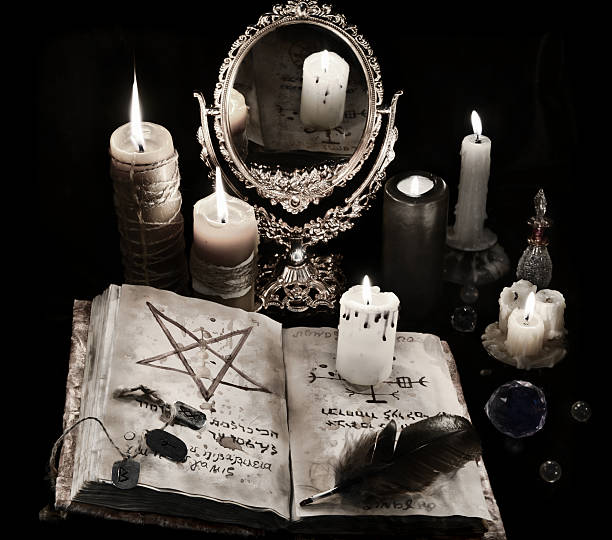 istock Mystic still life with black magic book, candles and mirrow 626787614