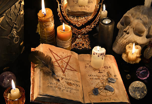 istock Mystic background with black magic book, candles and mirrow 626788428