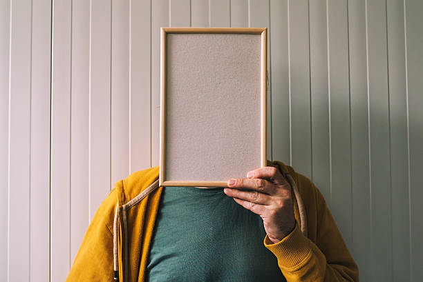 Unrecognizable man posing with blank picture frame over his face Unrecognizable man posing with blank picture frame over his face as copy space person holding frame over face stock pictures, royalty-free photos & images