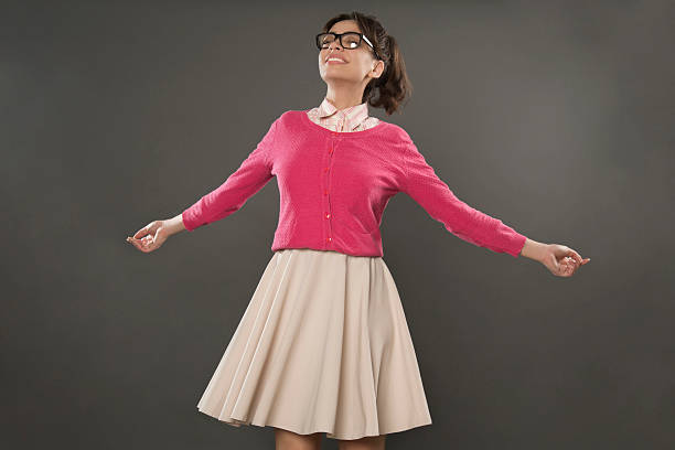 Cute, caucasian, nerd girl standing with her arms outstretched and smiling