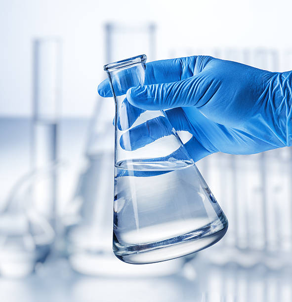 istock Laboratory beaker in analyst's hand in plastic glove. 626805026