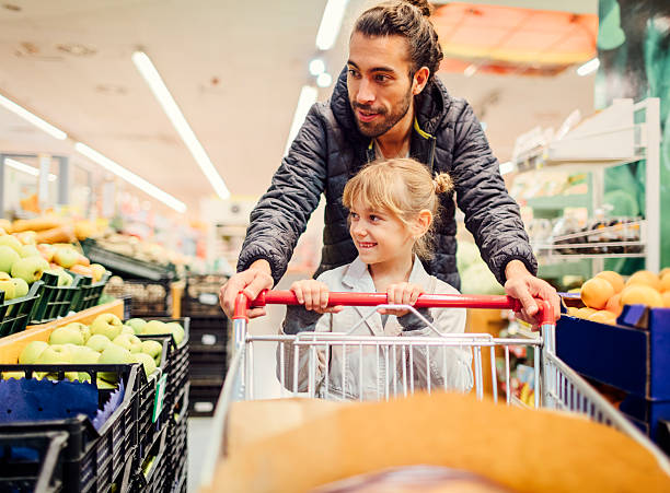 padre e sua figlia in un supermercato. - supermarket shopping retail choice foto e immagini stock