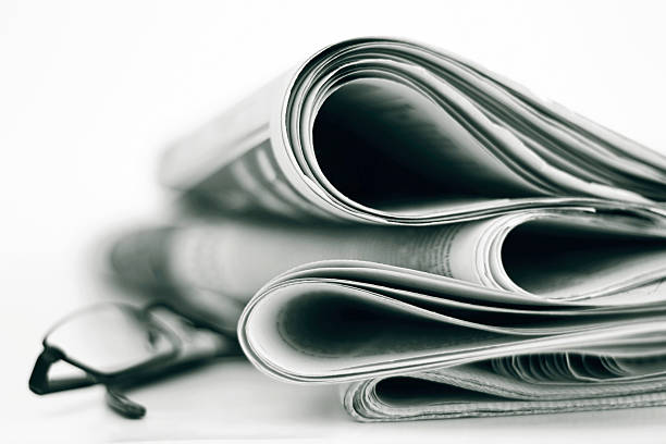 Newpapers A stack of newspapers with glasses. Shallow depth of field. newpapers stock pictures, royalty-free photos & images