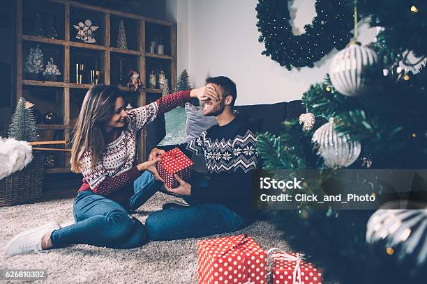 Mujer Cerrando Los Ojos Al Novio Dando Regalo Foto de stock y más banco de imágenes de Regalo de navidad - Regalo de navidad, Parejas, Regalo