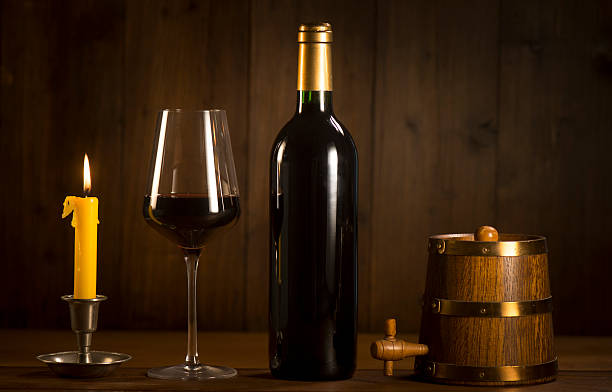istock Pouring red wine into wineglass from green bottle 626811976