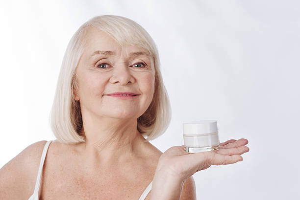 istock Pleasant smiling woman having a cream bottle in her hand 626812002