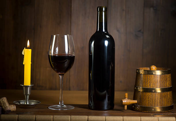 istock Pouring red wine into wineglass from green bottle 626812288