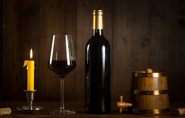istock Pouring red wine into wineglass from green bottle 626812418