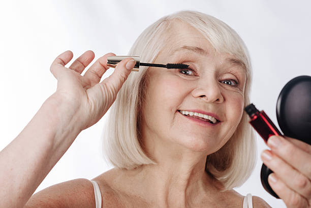istock Pleasant elderly woman holding a mascara brush 626813768