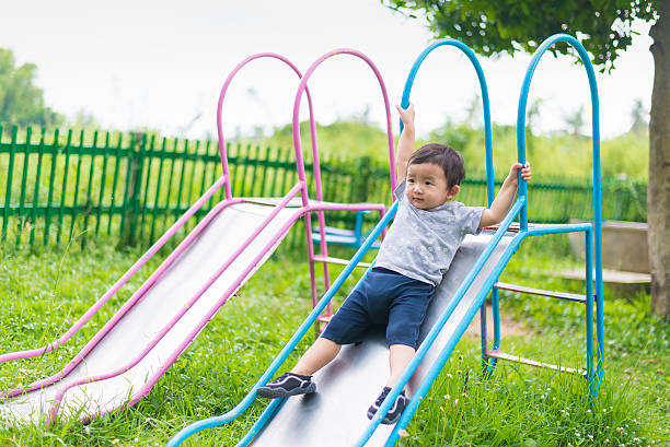 istock Little Asian kid playing slide at the playground 626815402