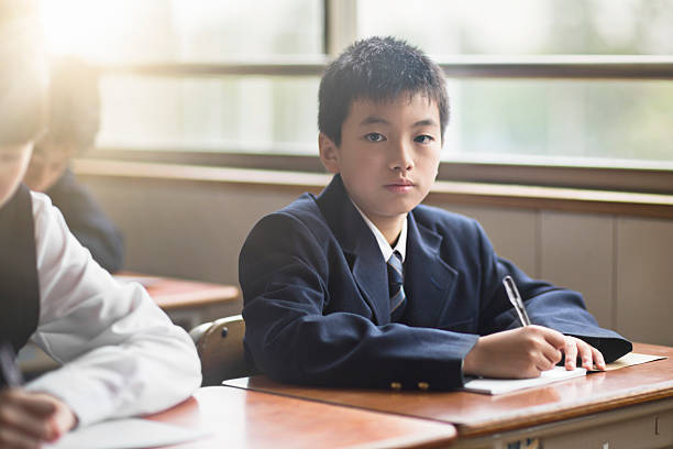 istock Portrait of confident high school boy in classroom 626816988