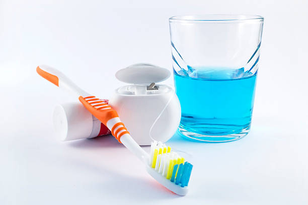 escova de dentes, fio dental, pasta de dente e enxaguante bucal em fundo branco - toothbrush plastic multi colored hygiene - fotografias e filmes do acervo
