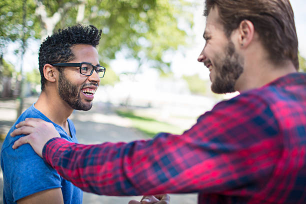 istock Cheerful young male friends talking on footpath 626830526