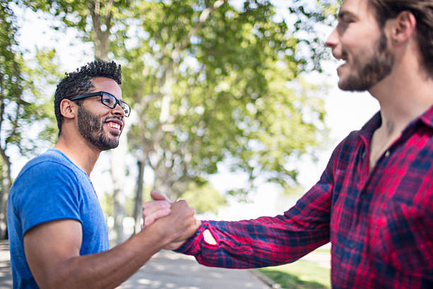 istock Happy man shaking hands with friend on footpath 626830560