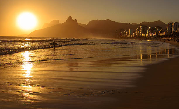 puesta de sol dorada con la montaña dois irmaos y la silueta del surfista, ipanema - brazil beach copacabana beach recreational pursuit fotografías e imágenes de stock