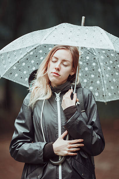 istock Young girl walking through a rainy forest with umbrella. 626836760