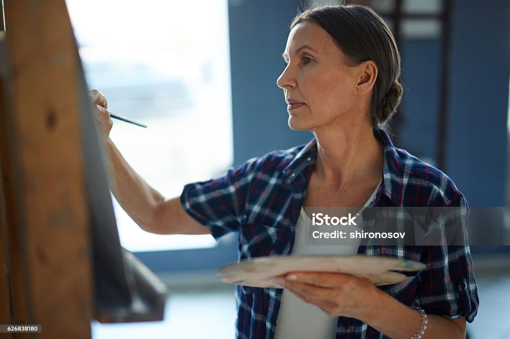 Painting in art studio Mature woman drawing with watercolors in art studio Painting - Activity Stock Photo