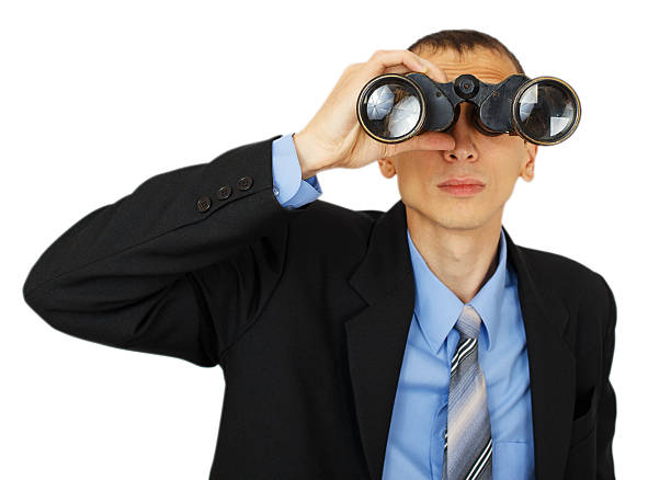 istock Business man wearing suit with blue tie with binoculars 626839116