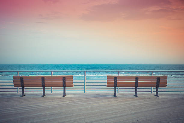 Sunset Benches beach pastel toned beach boardwalk benches with ocean and sunset boardwalk stock pictures, royalty-free photos & images