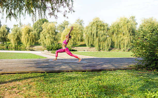 junge frau macht yoga mudras und posiert in einem park. - mudras stock-fotos und bilder