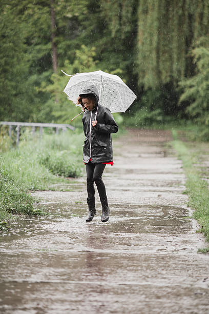 istock Young girl having fun in the rain. Joyful rain concept 626840976