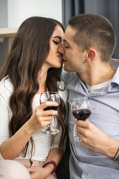 istock Young couple kissing and drinking red wine. 626841610