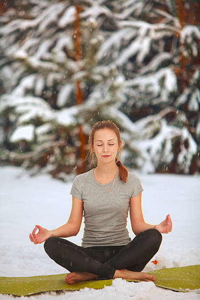 istock beautiful woman doing yoga outdoors in  snow 626842422