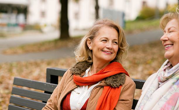 istock Two mature friends talking at the park. 626843964