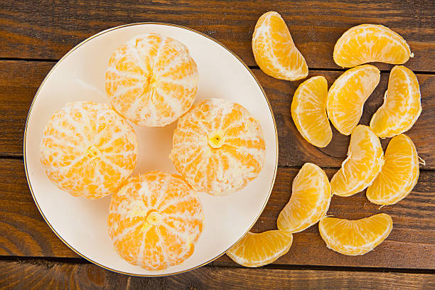 istock juicy Spanish mandarins on plate on wooden background 626844712