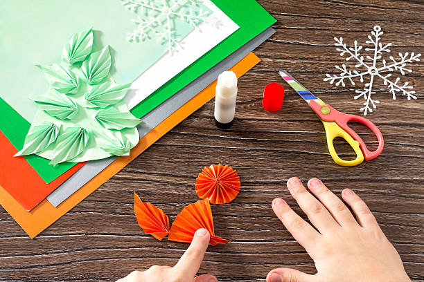 istock child makes a paper Christmas tree, snow, fox and bunny 626852720