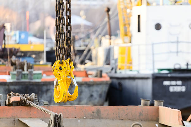 istock Yellow cargo hooks hanging on a steel chain. 626852726