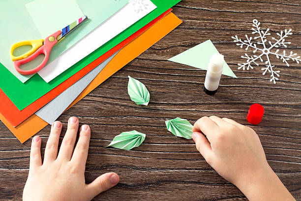 istock child makes a paper Christmas tree, snow, fox and bunny 626853166