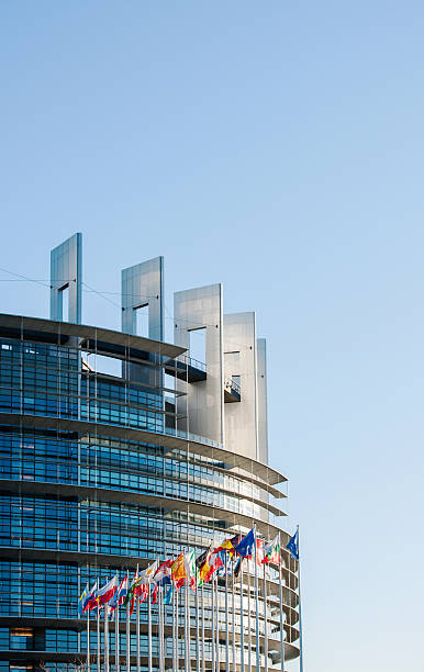 すべてのeu欧州連合の国旗を持つ欧州議会のファサード - flag greece european union flag coat of arms ストックフォトと画像