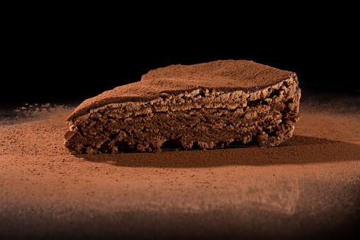 Chocolate cake over black background with reflection
