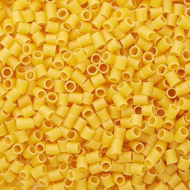Pile of dry ditalini yellow pasta as abstract background
