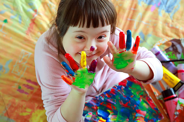 Cute little girl with painted hands Cute little girl with painted hands down syndrome stock pictures, royalty-free photos & images