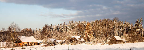 istock Sunny winter panorama of farm, fields and forests. 626862500