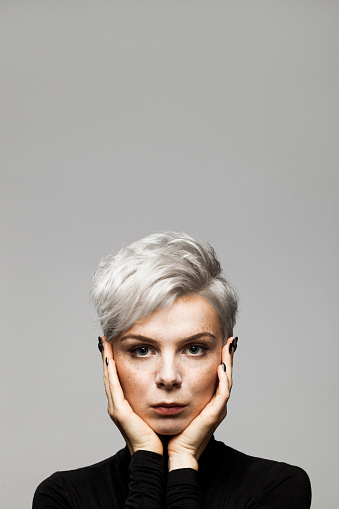 Creative portrait with lots of copy space above. Young woman looking seriously at camera.