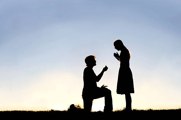 silhouette di giovane uomo con anello di fidanzamento che propone alla donna - engagement foto e immagini stock