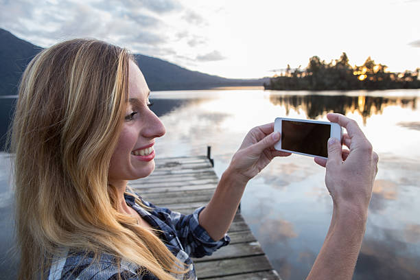 istock Young woman capturing landscape on smartphone 626866318