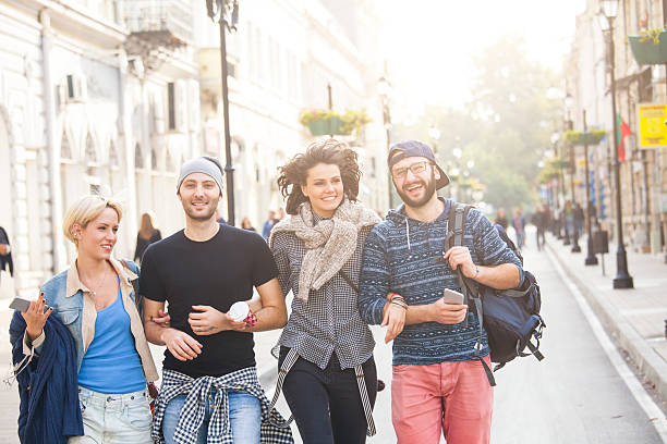 istock Smiling young friends walking on streets together 626868154
