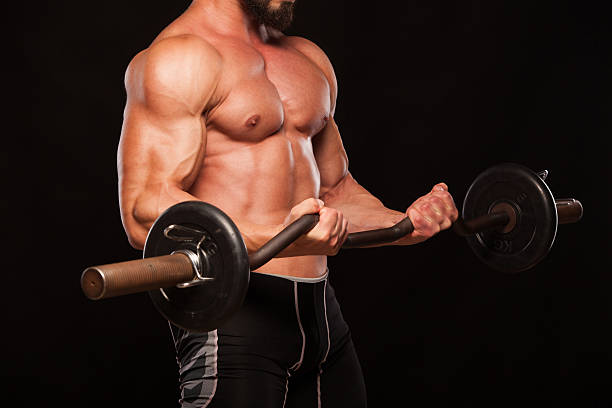 istock Muscular male athlete is training by lifting the barbell 626874036